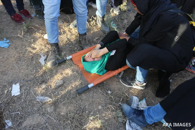 Palestinian Paramedics carry away an injured female protester during a protest by Palestinian women where Palestinians demand the right to return to their homeland along the border with Israel east of Gaza City on July 3...