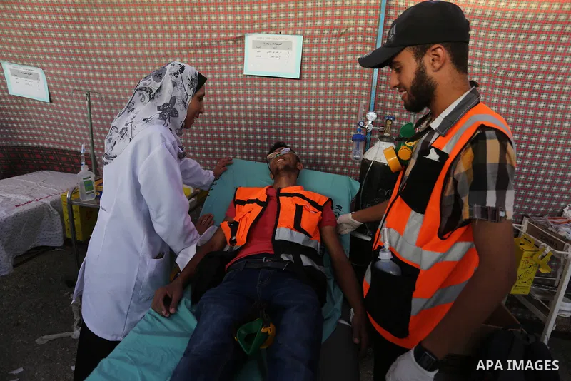 Palestinian Paramedics provide treatment for an injured protester during a protest by Palestinian women where Palestinians demand the right to return to their homeland along the border with Israel east of Gaza City on Ju...