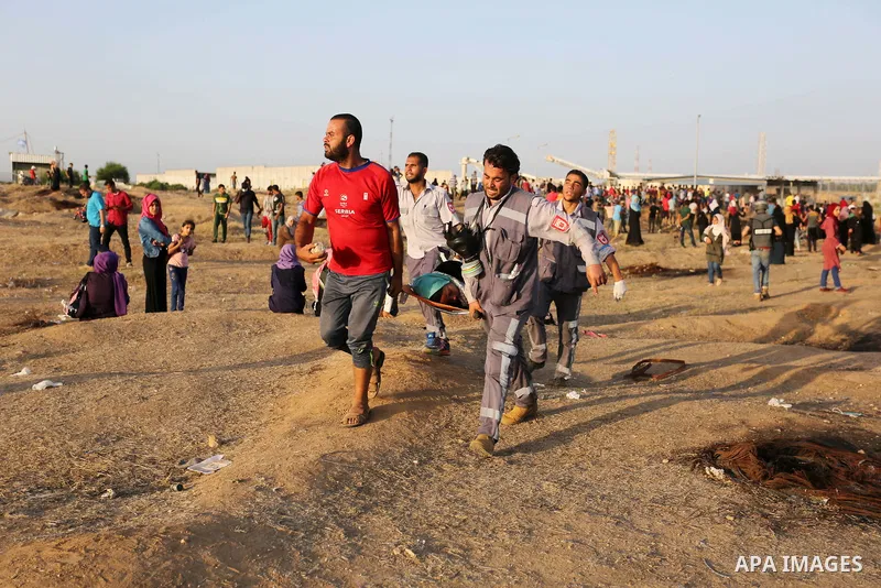 Palestinian Paramedics carry away an injured female protester during a protest by Palestinian women where Palestinians demand the right to return to their homeland along the border with Israel east of Gaza City on July 3...
