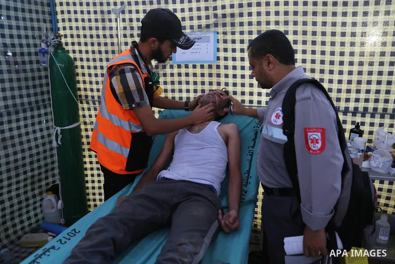 Palestinian Paramedics provide treatment for an injured protester during a protest by Palestinian women where Palestinians demand the right to return to their homeland along the border with Israel east of Gaza City on Ju...
