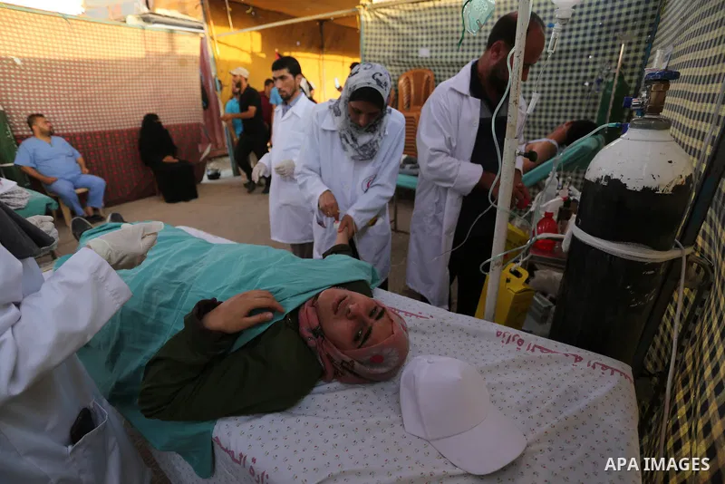 Palestinian Paramedics provide treatment for an injured protester during a protest by Palestinian women where Palestinians demand the right to return to their homeland along the border with Israel east of Gaza City on Ju...