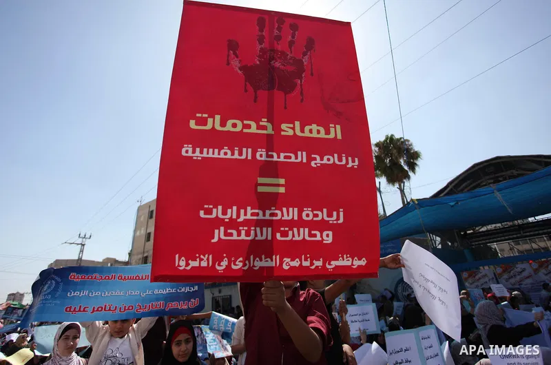 Palestinians hold banners during in a protest against a U.S. decision to cut aid, in front of the headquarters United Nations Relief and Works Agency (UNRWA), in Gaza City on July 4, 2018. Photo by Mahmoud Ajour