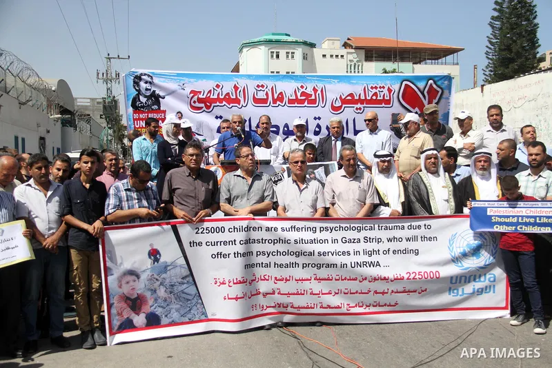 Palestinians hold banners during in a protest against a U.S. decision to cut aid, in front of the headquarters United Nations Relief and Works Agency (UNRWA), in Gaza City on July 4, 2018. Photo by Mahmoud Ajour