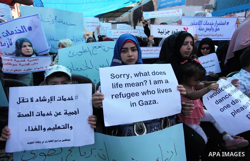 Palestinians hold banners during in a protest against a U.S. decision to cut aid, in front of the headquarters United Nations Relief and Works Agency (UNRWA), in Gaza City on July 4, 2018. Photo by Mahmoud Ajour