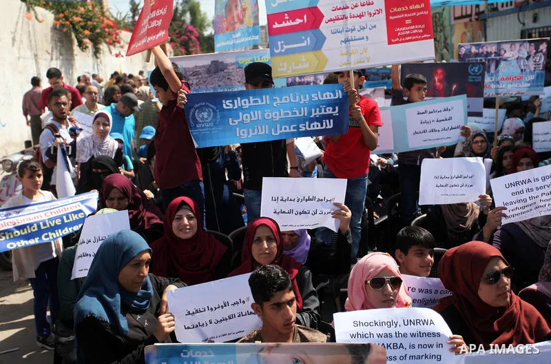 Palestinians hold banners during in a protest against a U.S. decision to cut aid, in front of the headquarters United Nations Relief and Works Agency (UNRWA), in Gaza City on July 4, 2018. Photo by Mahmoud Ajour