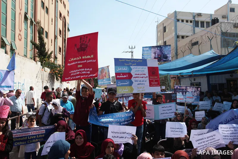 Palestinians hold banners during in a protest against a U.S. decision to cut aid, in front of the headquarters United Nations Relief and Works Agency (UNRWA), in Gaza City on July 4, 2018. Photo by Mahmoud Ajour