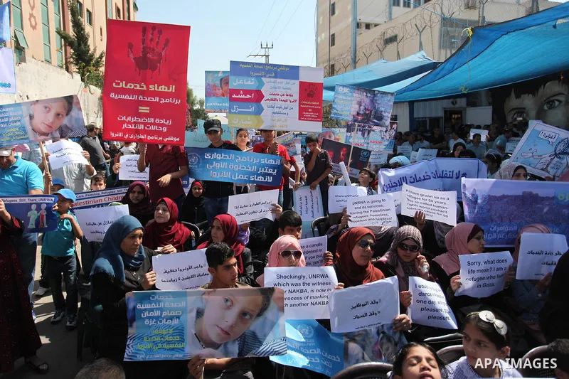 Palestinians hold banners during in a protest against a U.S. decision to cut aid, in front of the headquarters United Nations Relief and Works Agency (UNRWA), in Gaza City on July 4, 2018. Photo by Mahmoud Ajour