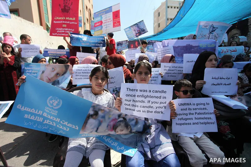 Palestinians hold banners during in a protest against a U.S. decision to cut aid, in front of the headquarters United Nations Relief and Works Agency (UNRWA), in Gaza City on July 4, 2018. Photo by Mahmoud Ajour