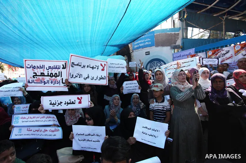 Palestinians hold banners during in a protest against a U.S. decision to cut aid, in front of the headquarters United Nations Relief and Works Agency (UNRWA), in Gaza City on July 4, 2018. Photo by Mahmoud Ajour