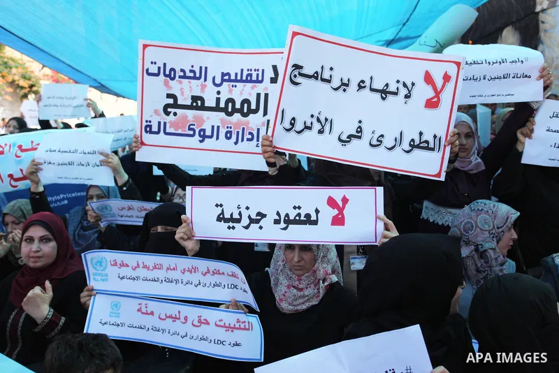 Palestinians hold banners during in a protest against a U.S. decision to cut aid, in front of the headquarters United Nations Relief and Works Agency (UNRWA), in Gaza City on July 4, 2018. Photo by Mahmoud Ajour