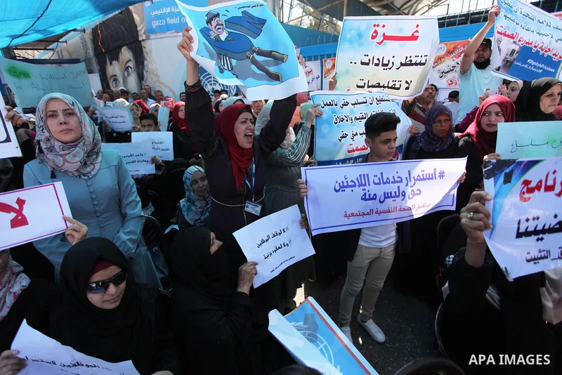 Palestinians hold banners during in a protest against a U.S. decision to cut aid, in front of the headquarters United Nations Relief and Works Agency (UNRWA), in Gaza City on July 4, 2018. Photo by Mahmoud Ajour