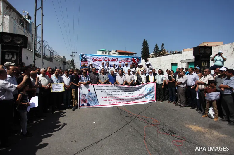 Palestinians hold banners during in a protest against a U.S. decision to cut aid, in front of the headquarters United Nations Relief and Works Agency (UNRWA), in Gaza City on July 4, 2018. Photo by Mahmoud Ajour