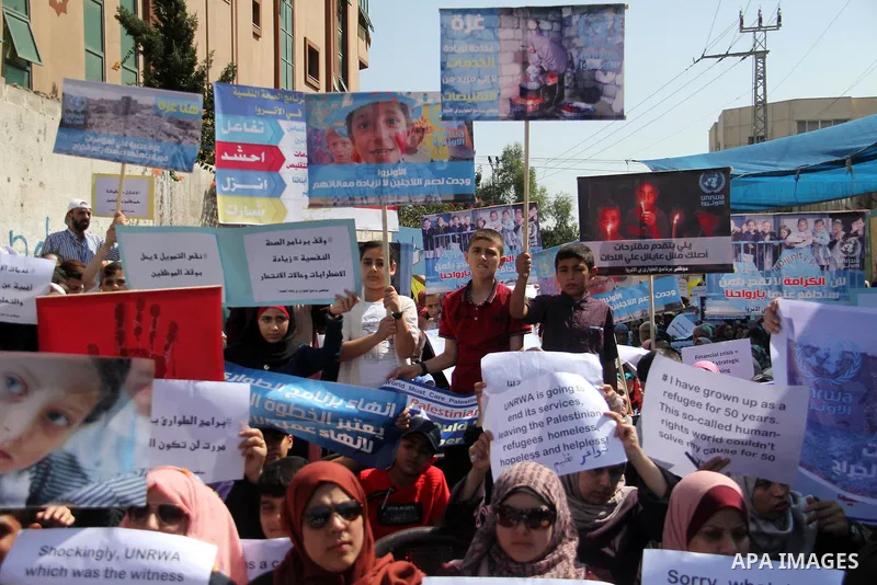 Palestinians hold banners during in a protest against a U.S. decision to cut aid, in front of the headquarters United Nations Relief and Works Agency (UNRWA), in Gaza City on July 4, 2018. Photo by Mahmoud Ajour