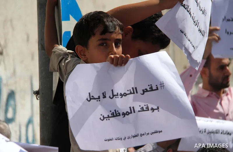 Palestinians hold banners during in a protest against a U.S. decision to cut aid, in front of the headquarters United Nations Relief and Works Agency (UNRWA), in Gaza City on July 4, 2018. Photo by Mahmoud Ajour