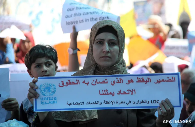 Palestinians hold banners during in a protest against a U.S. decision to cut aid, in front of the headquarters United Nations Relief and Works Agency (UNRWA), in Gaza City on July 4, 2018. Photo by Mahmoud Ajour