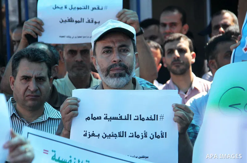 Palestinians hold banners during in a protest against a U.S. decision to cut aid, in front of the headquarters United Nations Relief and Works Agency (UNRWA), in Gaza City on July 4, 2018. Photo by Mahmoud Ajour