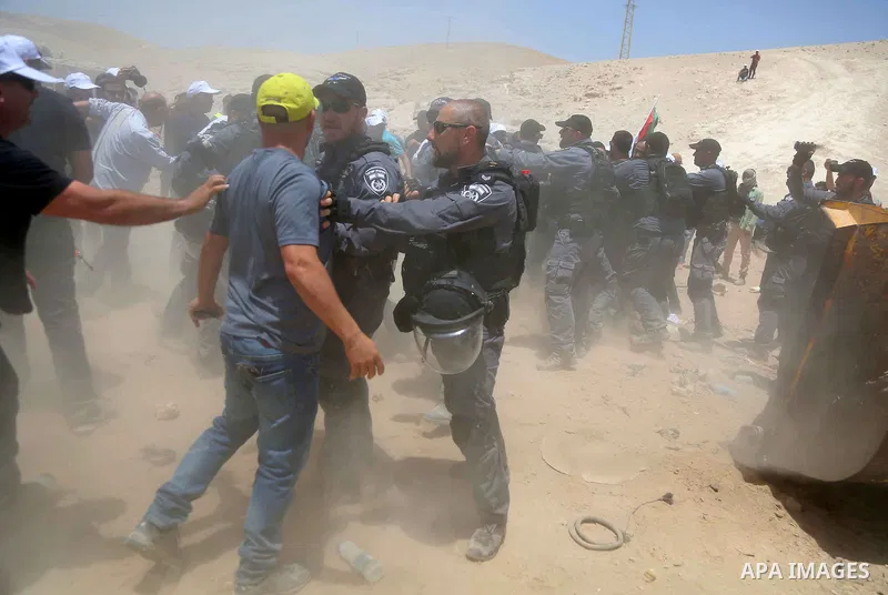 Israeli policemen scuffles with a Palestinian demonstrator in the Bedouin village of al-Khan al-Ahmar east of Jerusalem in the occupied West Bank on July 4, 2018. Residents and activists voiced concern today that Israel...