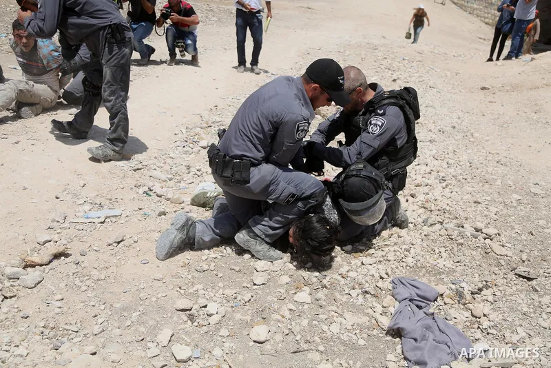 Israeli policemen detain a Palestinian female demonstrator in the Bedouin village of al-Khan al-Ahmar east of Jerusalem in the occupied West Bank on July 4, 2018. Residents and activists voiced concern today that Israel...