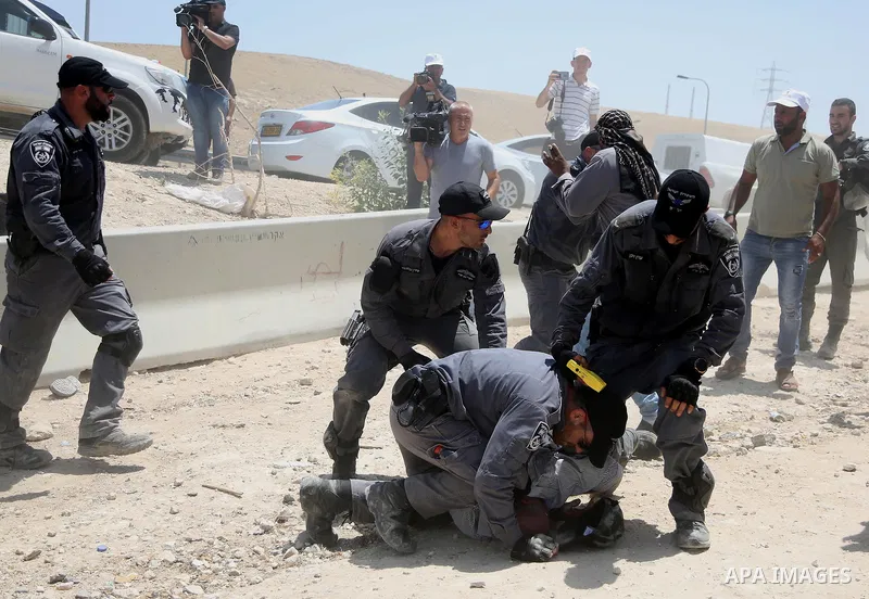 Israeli policemen detain a Palestinian demonstrator in the Bedouin village of al-Khan al-Ahmar east of Jerusalem in the occupied West Bank on July 4, 2018. Residents and activists voiced concern today that Israel is set...