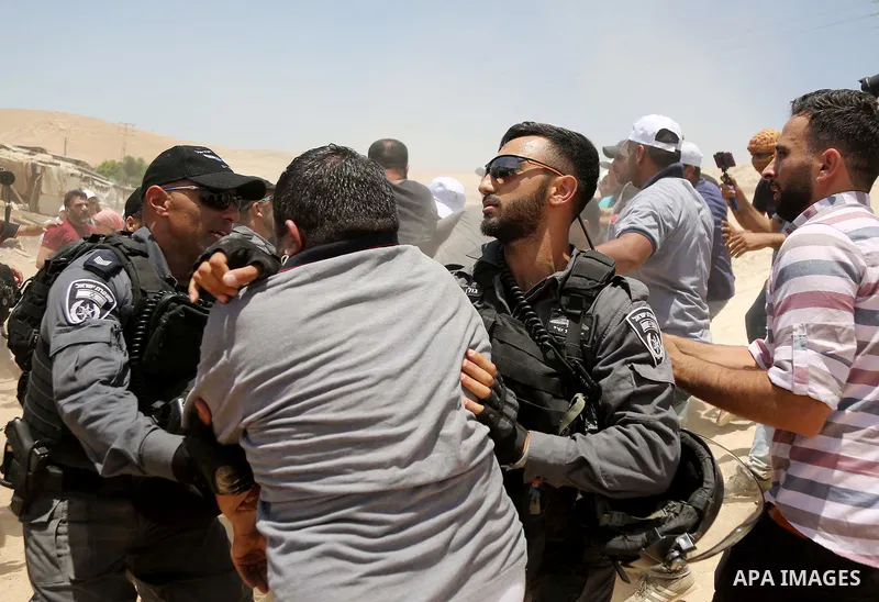 Israeli policemen scuffles with a Palestinian demonstrator in the Bedouin village of al-Khan al-Ahmar east of Jerusalem in the occupied West Bank on July 4, 2018. Residents and activists voiced concern today that Israel...