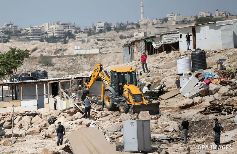 Israeli police secure a bulldozer demolishing structures at the Bedouin village of Abu Nuwar, near Abu Dis, east of Jerusalem in the occupied West Bank on July 4, 2018. Israel carried out a series of demolitions Wednesda...