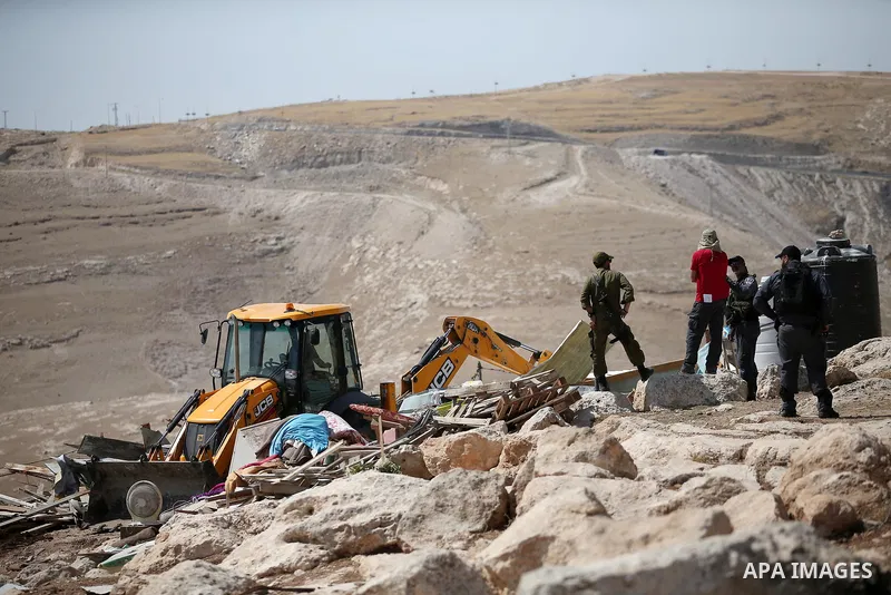 Israeli police secure a bulldozer demolishing structures at the Bedouin village of Abu Nuwar, near Abu Dis, east of Jerusalem in the occupied West Bank on July 4, 2018. Israel carried out a series of demolitions Wednesda...