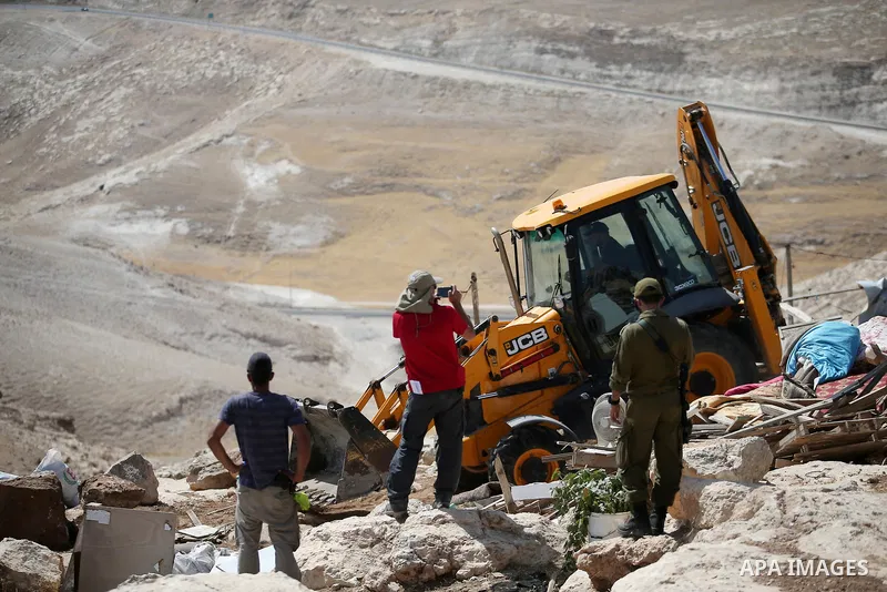 Israeli police secure a bulldozer demolishing structures at the Bedouin village of Abu Nuwar, near Abu Dis, east of Jerusalem in the occupied West Bank on July 4, 2018. Israel carried out a series of demolitions Wednesda...