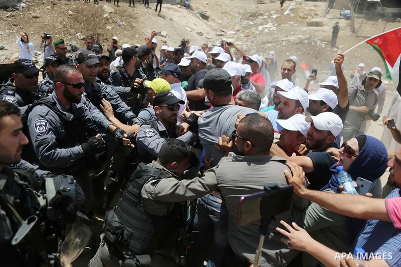 Israeli policemen scuffle with Palestinian demonstrators in the Bedouin village of al-Khan al-Ahmar east of Jerusalem in the occupied West Bank on July 4, 2018. Residents and activists voiced concern today that Israel is...