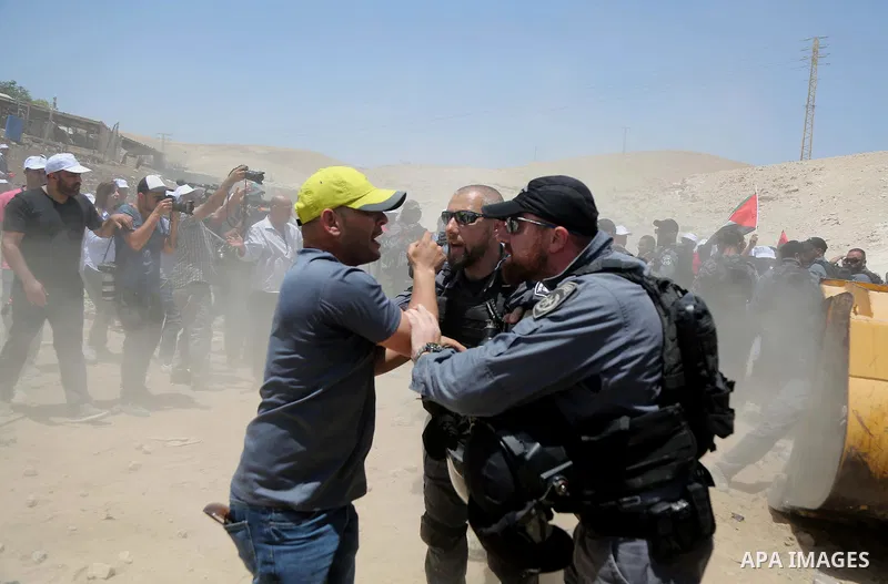 Israeli policemen scuffles with a Palestinian demonstrator in the Bedouin village of al-Khan al-Ahmar east of Jerusalem in the occupied West Bank on July 4, 2018. Residents and activists voiced concern today that Israel...