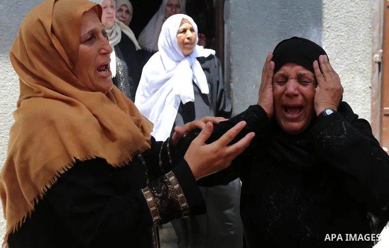 Relatives of Palestinian Mahmoud al-Ghrabli ,16, who died of wounds he sustained during clashes with Israeli troops, mourn during his funeral in Gaza city on July 5, 2018. Photo by Ashraf Amra