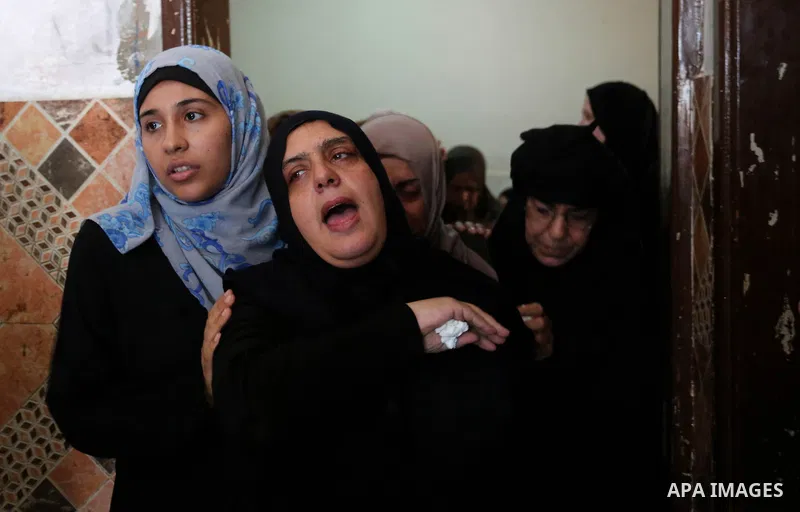 Relatives of Palestinian Mahmoud al-Ghrabli ,16, who died of wounds he sustained during clashes with Israeli troops, mourn during his funeral in Gaza city on July 5, 2018. Photo by Ashraf Amra