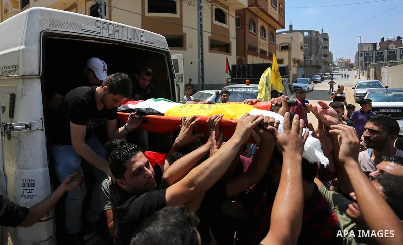 Mourners carry the body of Palestinian Mahmoud al-Ghrabli ,16, who died of wounds he sustained during clashes with Israeli troops, his funeral in Gaza city on July 5, 2018. Photo by Ashraf Amra