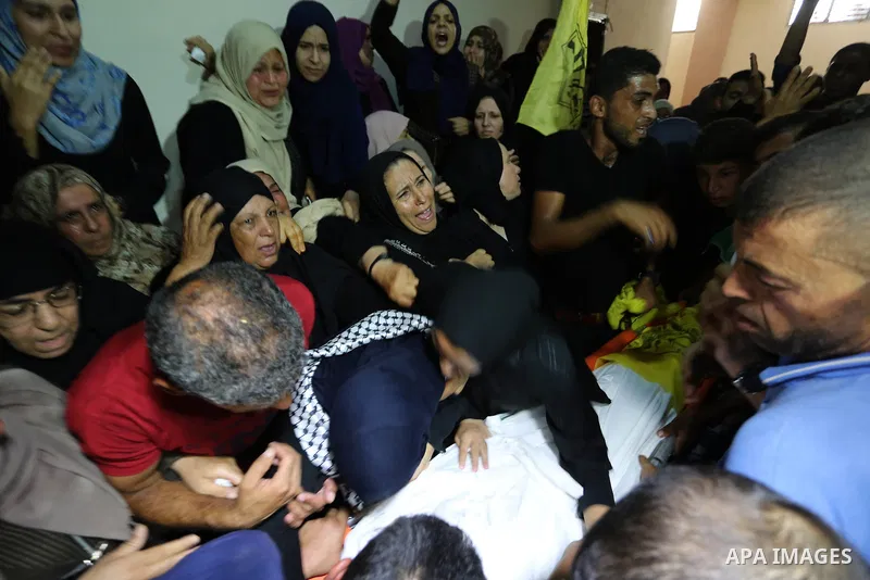 Relatives of Palestinian Mahmoud al-Ghrabli ,16, who died of wounds he sustained during clashes with Israeli troops, mourn during his funeral in Gaza city on July 5, 2018. Photo by Ashraf Amra