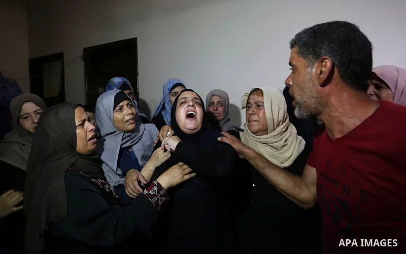 Relatives of Palestinian Mahmoud al-Ghrabli ,16, who died of wounds he sustained during clashes with Israeli troops, mourn during his funeral in Gaza city on July 5, 2018. Photo by Ashraf Amra