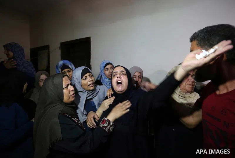 Relatives of Palestinian Mahmoud al-Ghrabli ,16, who died of wounds he sustained during clashes with Israeli troops, mourn during his funeral in Gaza city on July 5, 2018. Photo by Ashraf Amra
