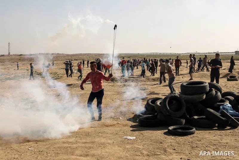 Palestinian protesters gather during clashes with Israeli troops in tents protest where Palestinian demand the right to return to their homeland at the Israel-Gaza border, in east of Gaza City on July 6, 2018. Photo by D...