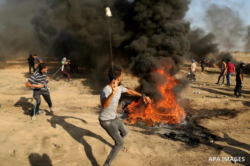 Palestinian protesters gather during clashes with Israeli troops in tents protest where Palestinian demand the right to return to their homeland at the Israel-Gaza border, in east of Gaza City on July 6, 2018. Photo by D...