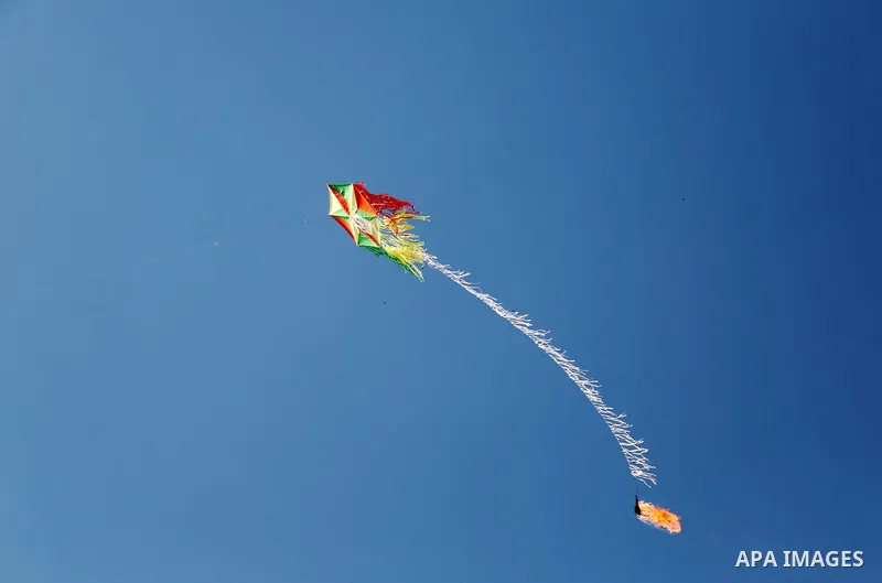 A kite laden with flammable material is seen flew over the border before cutting the string leaving the burning material to fall in Israeli territory, on the border between Israel and the Gaza Strip, east of Gaza City on...