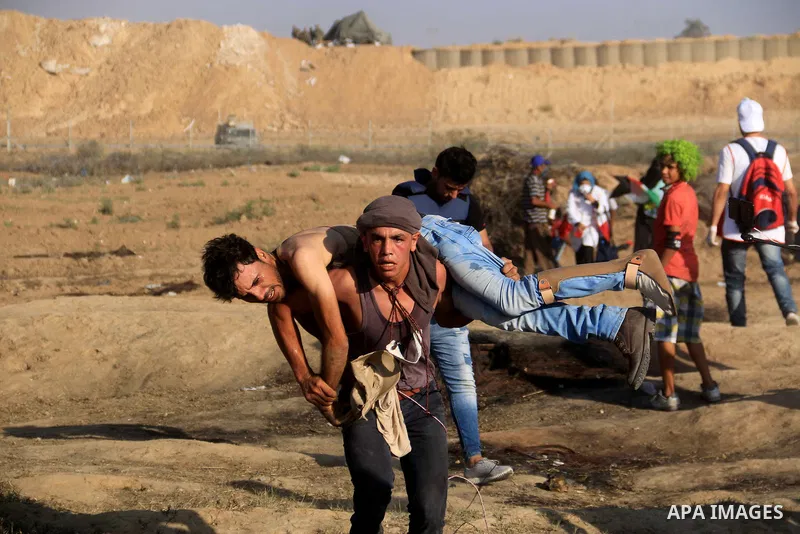 A wounded Palestinian protester is evacuated during clashes with Israeli troops in tents protest where Palestinian demand the right to return to their homeland at the Israel-Gaza border, in al-Bureij in the center of Gaz...