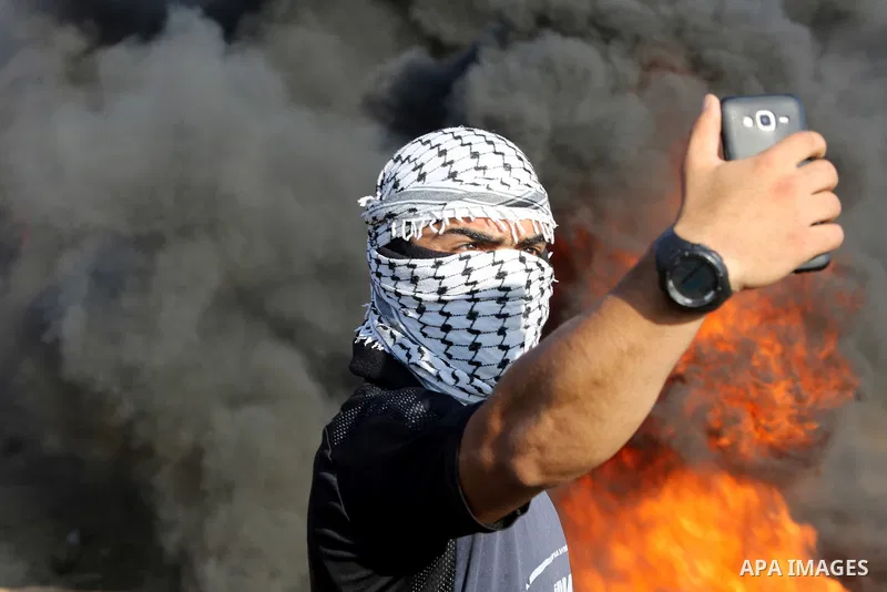 Palestinian protesters gather during clashes with Israeli troops in tents protest where Palestinian demand the right to return to their homeland at the Israel-Gaza border, in east of Gaza City on July 6, 2018. Photo by A...