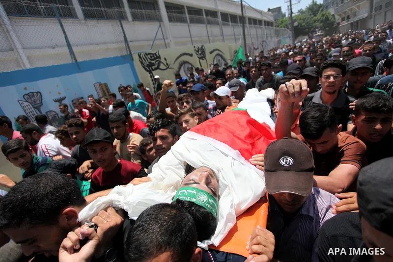 Mourners carry the body of Palestinian Mohammed Abu Halima, 22, who was shot dead by Israeli troops during clashes at Gaza-Israel border, during his funeral in Gaza city on July 7, 2018. Photo by Mahmoud Ajour