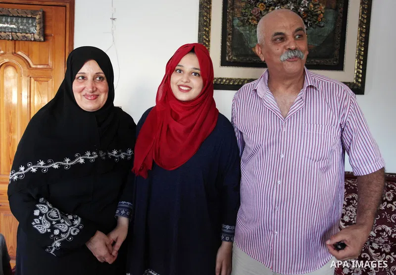 A Palestinian high school female student, Hala Qassem, 99.3%, celebrates with her family after heard the results of her final exams known as ''Tawjihi'', in Deir al Balah in the center of Gaza Strip on July 8, 2018. Phot...