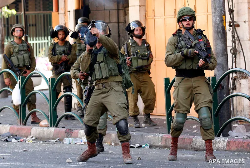 Israeli troops take position during clashes with Palestinian protesters in the West Bank city of Hebron on July 13, 2018. Photo by Wisam Hashlamoun