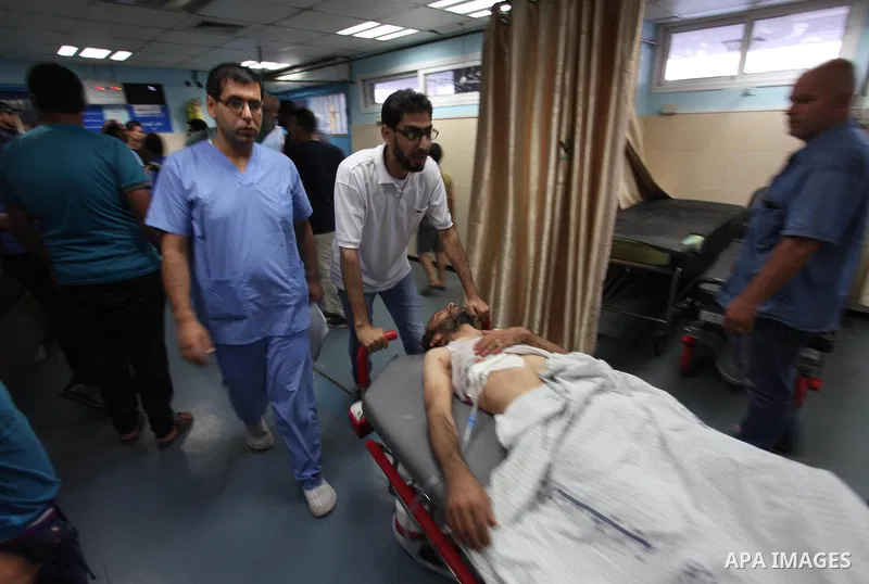 Medics treat a Palestinian man who was injured during an Israeli air strike on Gaza city, at al-Shifa hospital, 14 July 2018. At least two Palestinians were killed after an Israeli air strike on Gaza City. The building i...