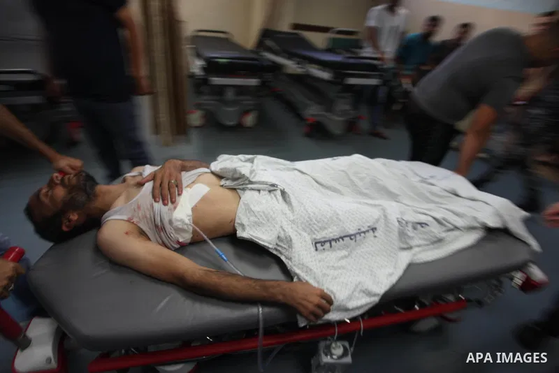 Medics treat a Palestinian man who was injured during an Israeli air strike on Gaza city, at al-Shifa hospital, 14 July 2018. At least two Palestinians were killed after an Israeli air strike on Gaza City. The building i...