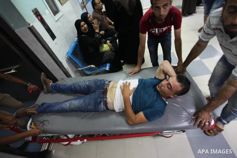 Medics treat a Palestinian man who was injured during an Israeli air strike on Gaza city, at al-Shifa hospital, 14 July 2018. At least two Palestinians were killed after an Israeli air strike on Gaza City. The building i...
