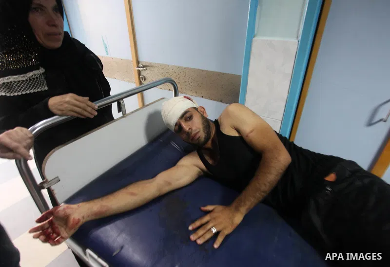 Medics treat a Palestinian man who was injured during an Israeli air strike on Gaza city, at al-Shifa hospital, 14 July 2018. At least two Palestinians were killed after an Israeli air strike on Gaza City. The building i...