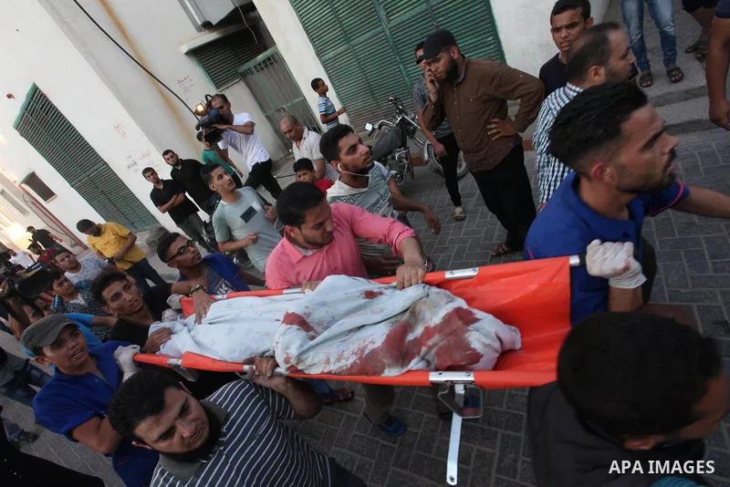 Palestinian medics carry the body of 16-year-old Loay Kuhail, who was killed during an Israeli air strike on Gaza city, at al-Shifa hospital, 14 July 2018. At least two Palestinians were killed after an Israeli air strik...