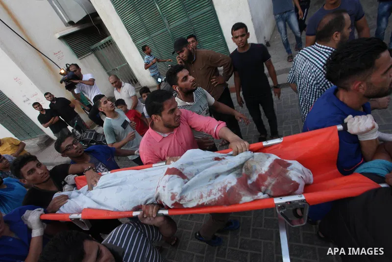 Palestinian medics carry the body of 16-year-old Loay Kuhail, who was killed during an Israeli air strike on Gaza city, at al-Shifa hospital, 14 July 2018. At least two Palestinians were killed after an Israeli air strik...