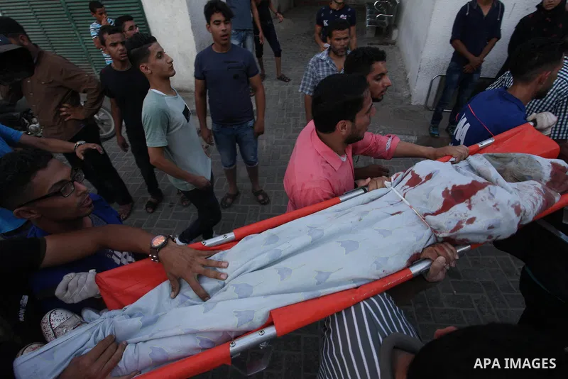 Palestinian medics carry the body of 16-year-old Loay Kuhail, who was killed during an Israeli air strike on Gaza city, at al-Shifa hospital, 14 July 2018. At least two Palestinians were killed after an Israeli air strik...